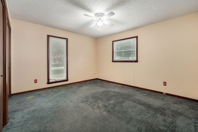 unfurnished room featuring dark carpet, a textured ceiling, and ceiling fan