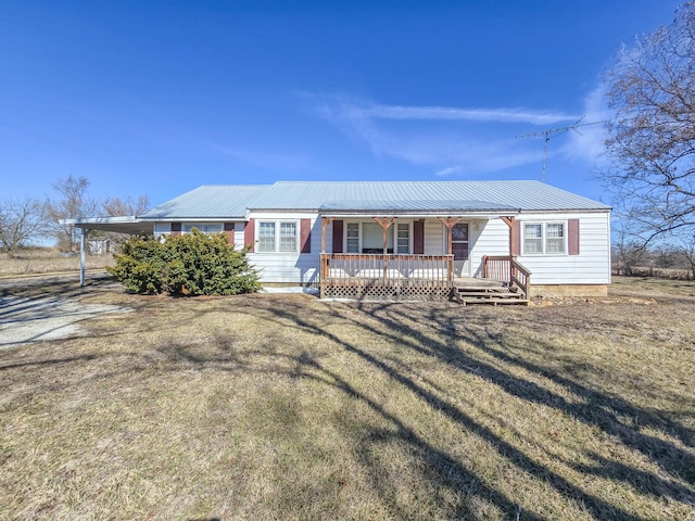 view of front of home with a carport, metal roof, a front lawn, and a porch