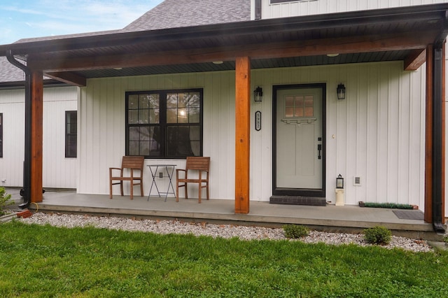 entrance to property featuring a lawn and covered porch