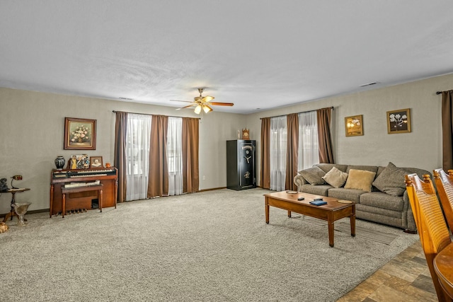 living room featuring ceiling fan, light colored carpet, and a healthy amount of sunlight