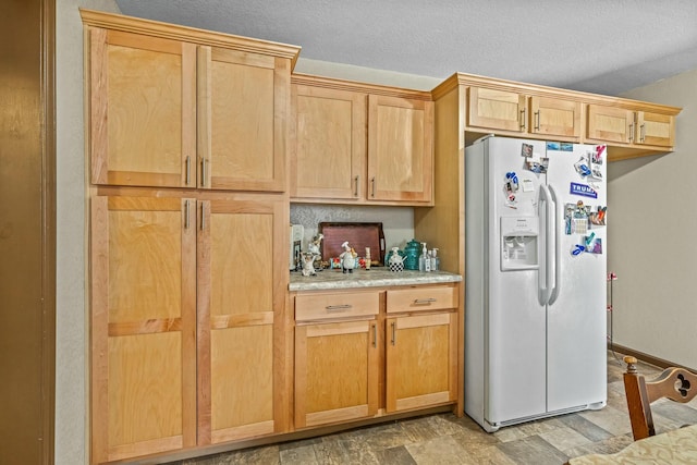 kitchen with white refrigerator with ice dispenser and a textured ceiling