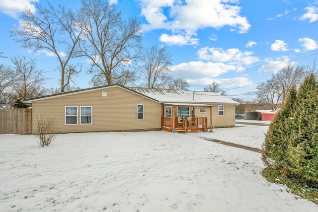 snow covered rear of property featuring a deck