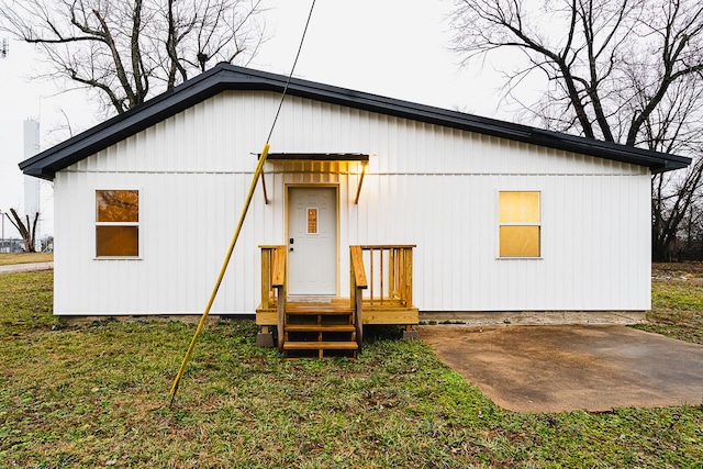 rear view of property featuring a patio area and a lawn