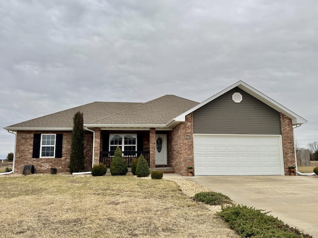 ranch-style house featuring a garage, covered porch, and a front lawn