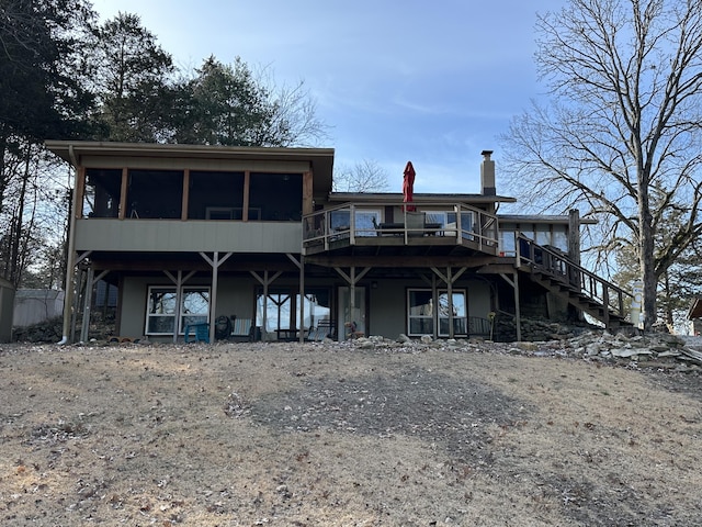 back of property featuring a wooden deck and a sunroom