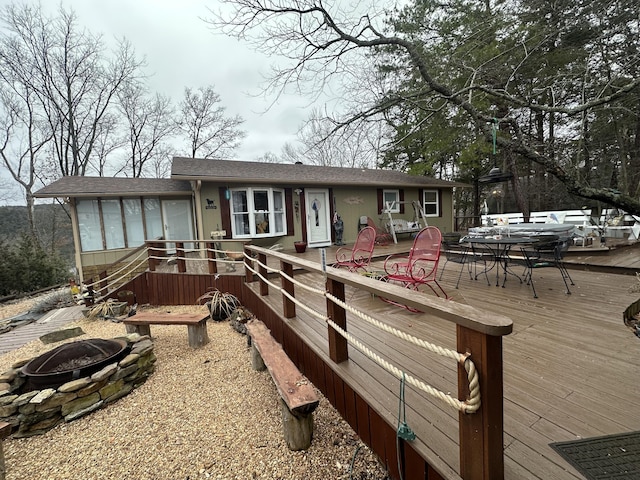 view of front of property featuring a wooden deck and a fire pit