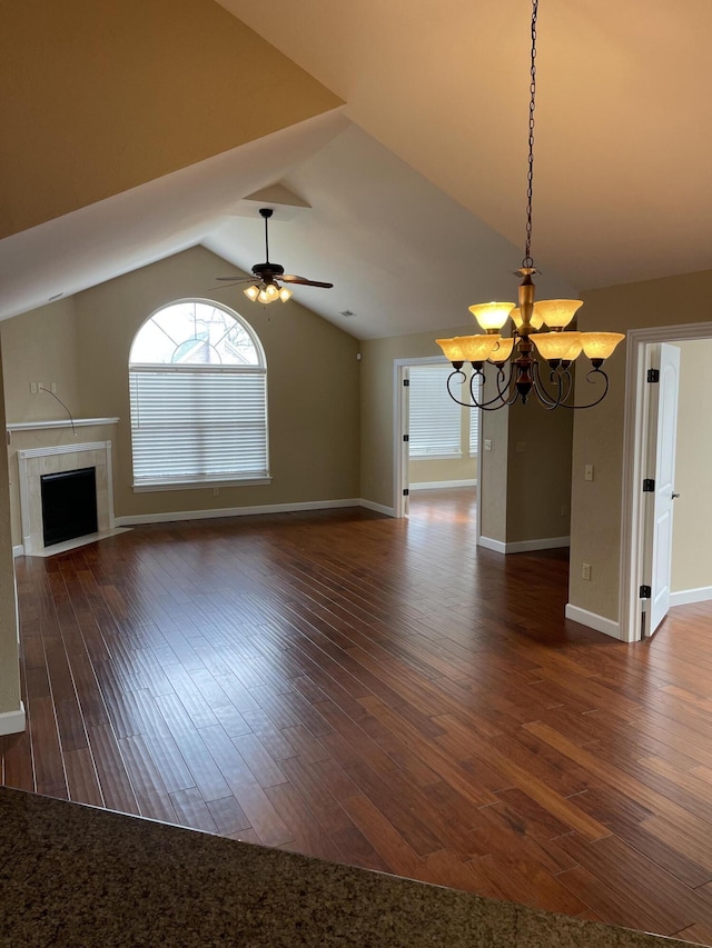 unfurnished living room featuring dark hardwood / wood-style flooring, ceiling fan with notable chandelier, and a fireplace