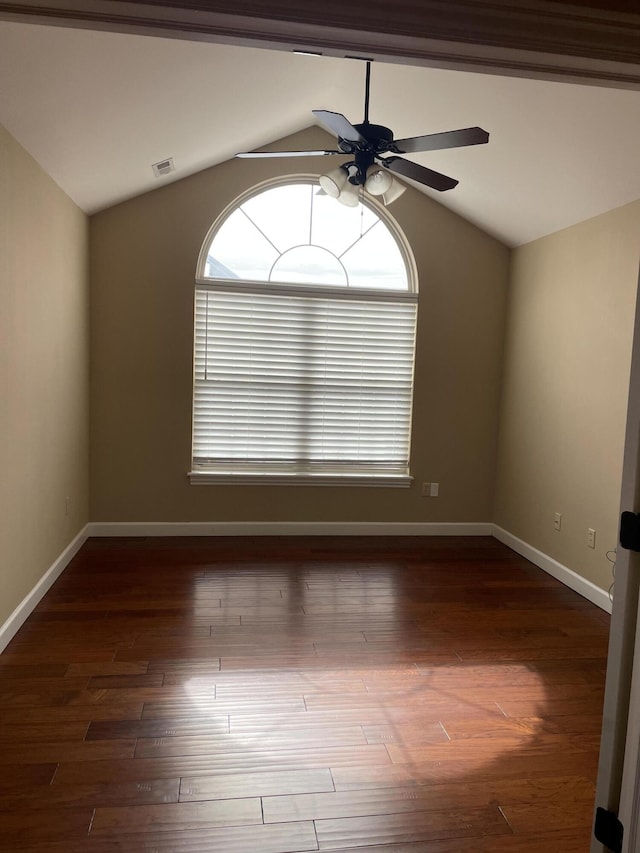 spare room with plenty of natural light, dark hardwood / wood-style flooring, and vaulted ceiling