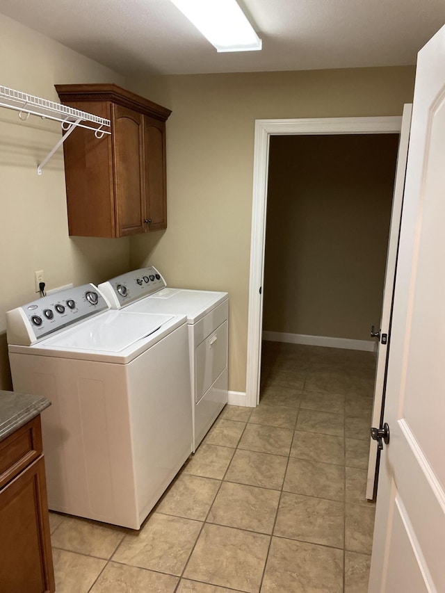 laundry area with cabinets, separate washer and dryer, and light tile patterned floors