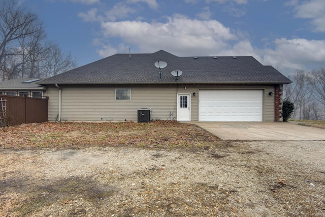 back of house featuring a garage and central AC