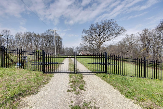 view of gate featuring a yard and fence