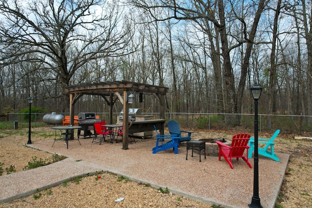 view of play area featuring a pergola, fence, and a fire pit