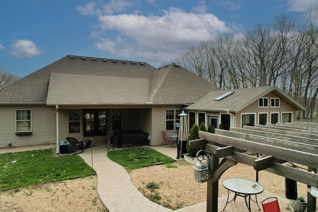 rear view of house with a patio area, french doors, and a shingled roof