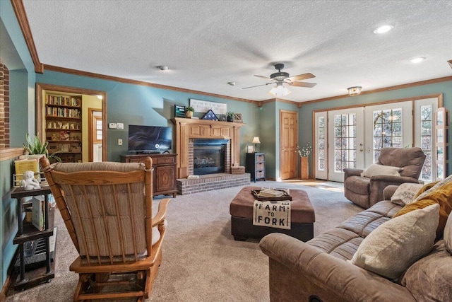 living room with a fireplace, ornamental molding, a textured ceiling, light colored carpet, and french doors