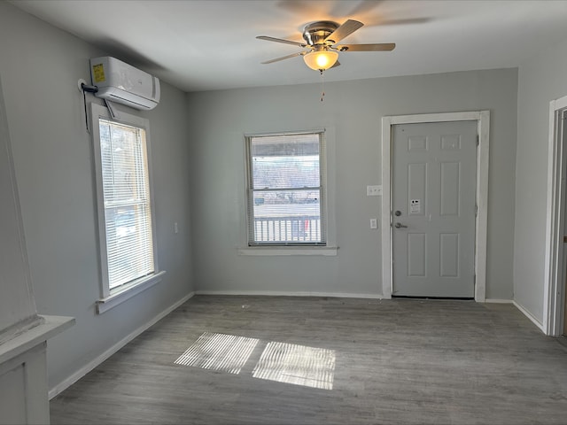 entryway with an AC wall unit, plenty of natural light, and baseboards