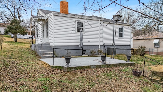 back of property with a patio, a yard, and central AC