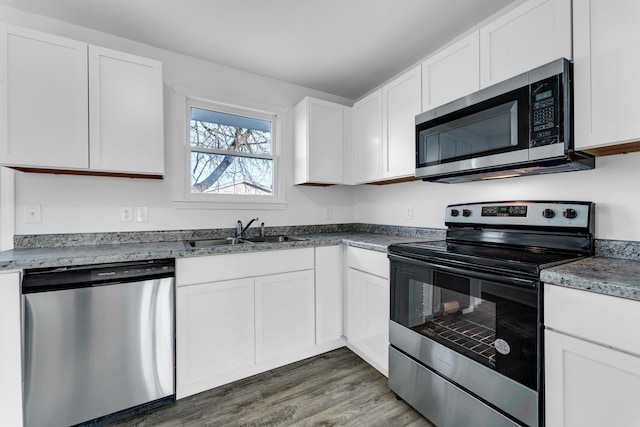 kitchen with white cabinetry, stainless steel appliances, and sink