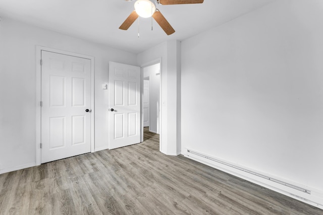 unfurnished bedroom with a baseboard heating unit, ceiling fan, and light hardwood / wood-style flooring