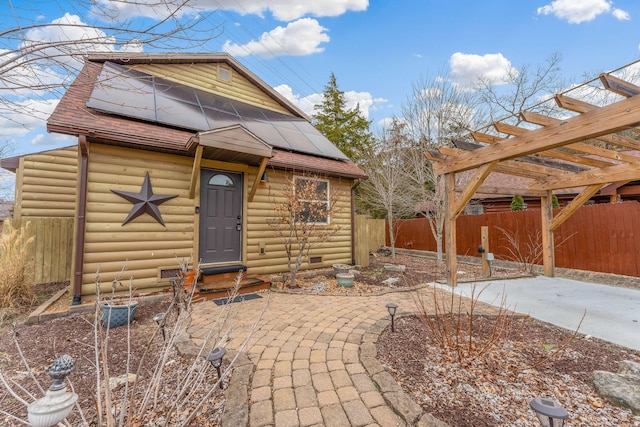 view of front of house with a patio and solar panels