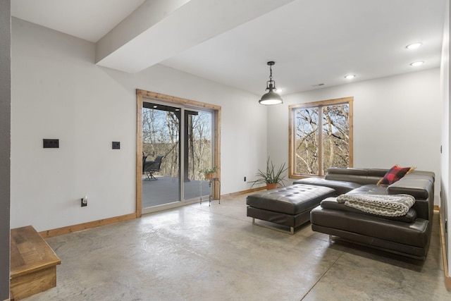 sitting room with a healthy amount of sunlight, baseboards, and concrete flooring