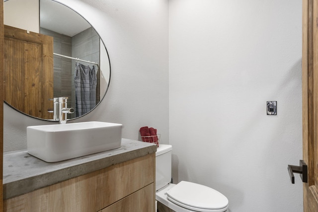 bathroom featuring toilet, curtained shower, and vanity