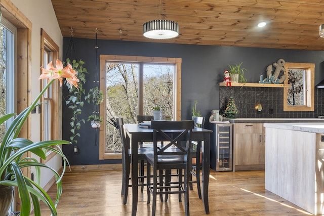 dining space featuring light wood-type flooring, wooden ceiling, and vaulted ceiling