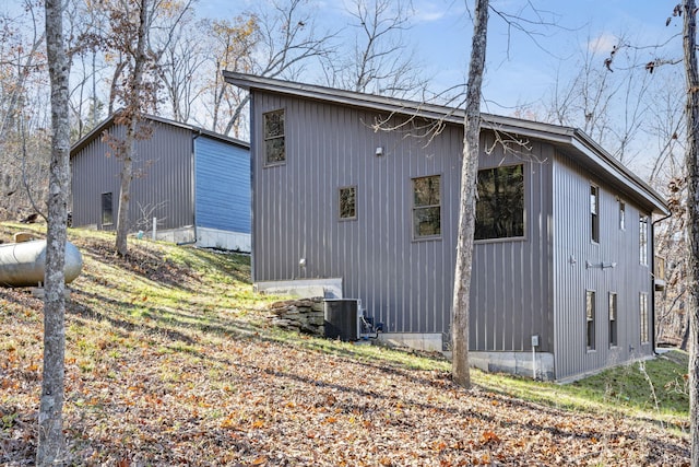 view of side of property featuring cooling unit and an outbuilding