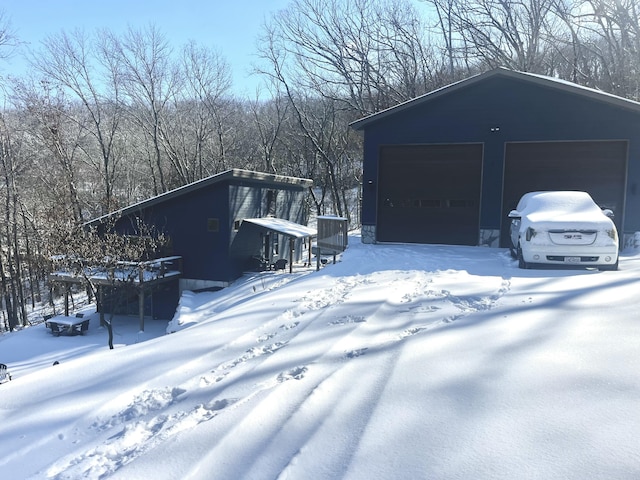 snow covered garage with a detached garage