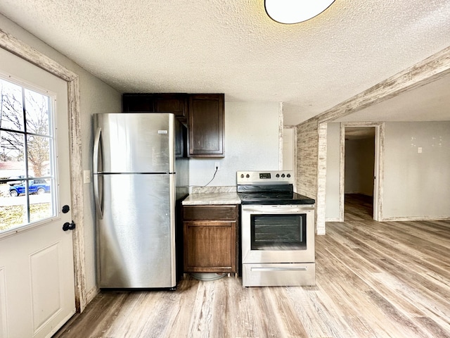 kitchen featuring dark brown cabinetry, light wood-type flooring, and stainless steel appliances