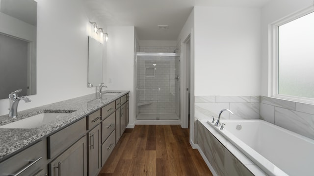 bathroom featuring vanity, plus walk in shower, and wood-type flooring