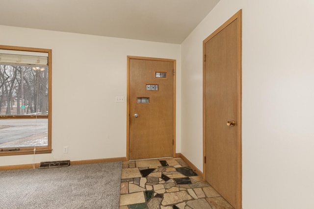 doorway to outside featuring light carpet and a wealth of natural light