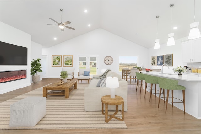 living room featuring sink, ceiling fan, high vaulted ceiling, and light hardwood / wood-style floors