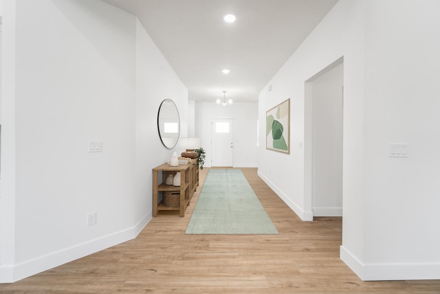 foyer entrance featuring a notable chandelier and light wood-type flooring