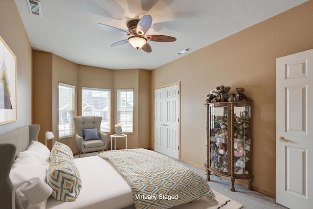 carpeted bedroom featuring a textured ceiling, a closet, and ceiling fan