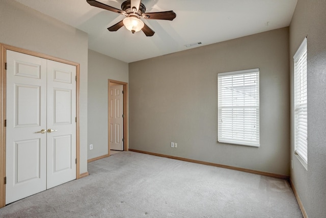 unfurnished bedroom with ceiling fan, light colored carpet, and a closet