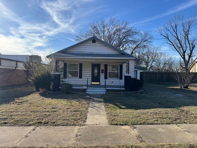 bungalow-style home with a front yard and a porch