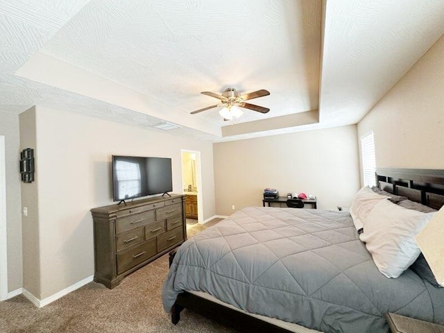 bedroom with ceiling fan, a raised ceiling, a textured ceiling, and light colored carpet