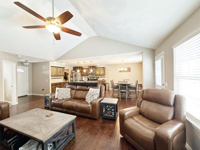 living room with vaulted ceiling, dark hardwood / wood-style floors, and ceiling fan with notable chandelier