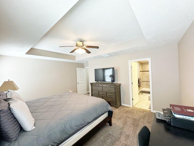 bedroom featuring carpet, ceiling fan, a raised ceiling, a textured ceiling, and ensuite bathroom