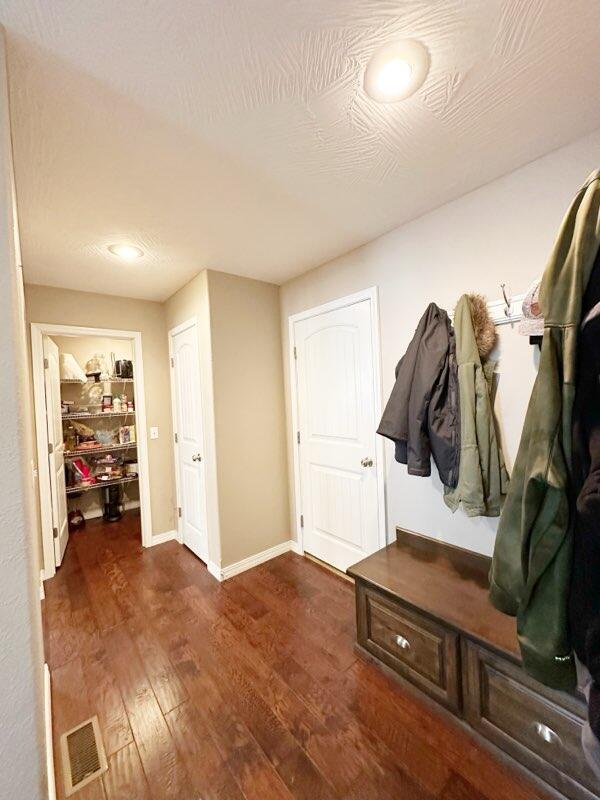 mudroom with a textured ceiling and dark hardwood / wood-style floors