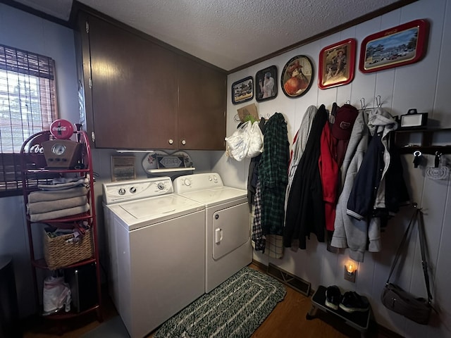 washroom featuring dark wood-type flooring, washer and dryer, cabinets, and a textured ceiling