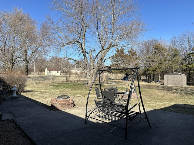 view of yard with a storage shed, a fire pit, an outbuilding, and a patio