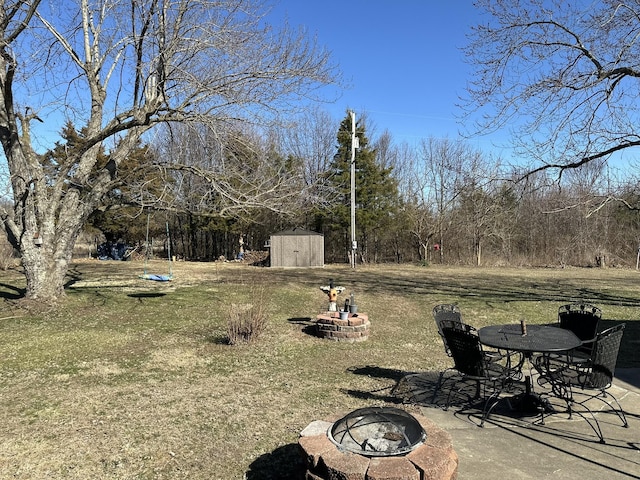view of yard featuring an outdoor fire pit, an outdoor structure, a patio, and a shed