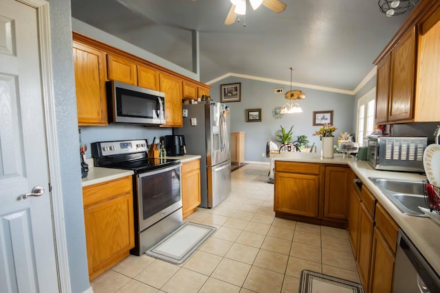 kitchen with lofted ceiling, stainless steel appliances, decorative light fixtures, sink, and light tile patterned floors