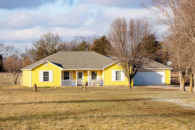 ranch-style home with covered porch, a front yard, and a garage