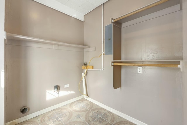 laundry area with baseboards and light tile patterned floors