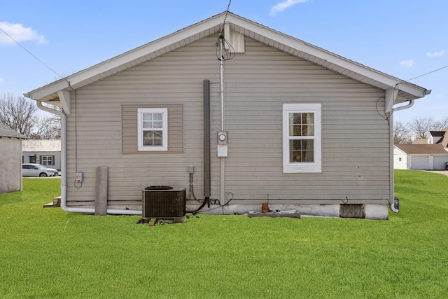 rear view of house with a yard and central air condition unit