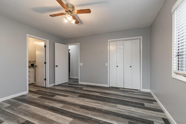 unfurnished bedroom featuring dark hardwood / wood-style flooring, multiple windows, and a closet