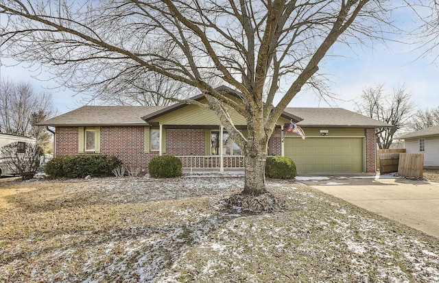 single story home with a garage, covered porch, brick siding, fence, and driveway