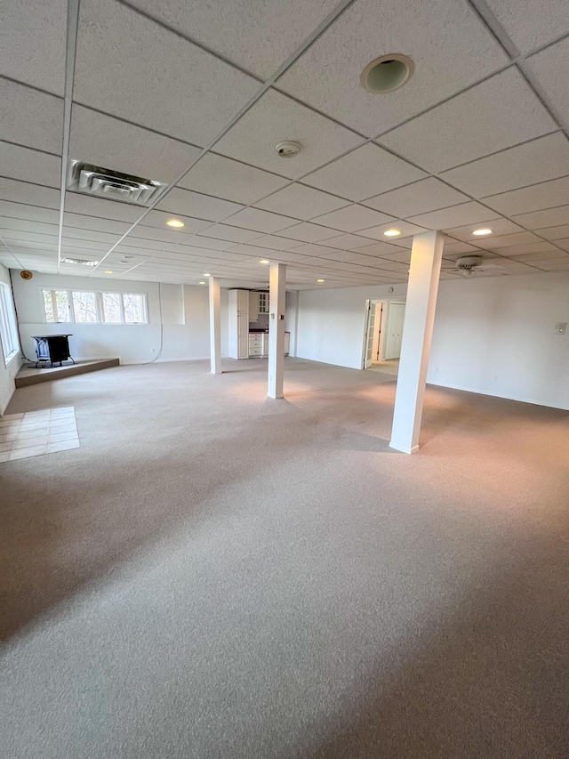 basement featuring a paneled ceiling and carpet floors